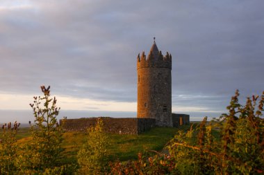 İrlanda Doonegore Şatosu ve Doolin ve Aran Adaları kıyı sahili manzaralı güzel bir gün batımı manzarası..