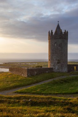İrlanda Doonegore Şatosu ve Doolin ve Aran Adaları kıyı sahili manzaralı güzel bir gün batımı manzarası..
