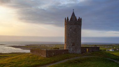 İrlanda Doonegore Şatosu ve Doolin ve Aran Adaları kıyı sahili manzaralı güzel bir gün batımı manzarası..