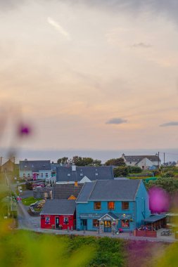 Doolin, İrlanda - 3 Ağustos 2025: Clare İrlanda 'da geleneksel renkli kulübelerle eski Doolin köyünün panoramik manzarası. 
