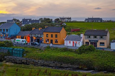 Doolin, İrlanda - 3 Ağustos 2025: Clare İrlanda 'da geleneksel renkli kulübelerle eski Doolin köyünün panoramik manzarası. 