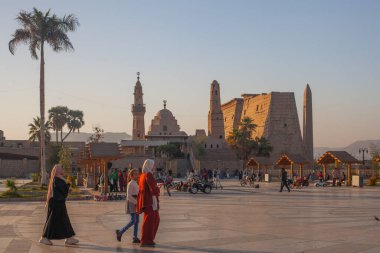 Luxor, Mısır - 10 Mart 2025: Yerliler Luxor Tapınak Meydanı 'nda harika bir günbatımı akşamının tadını çıkarıyorlar. Luxor Tapınağı ve Abou al-Haggag Mosqu 'nun genel görüşü 