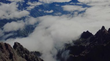 Bulutların üstündeki hava manzarası Caldera de Taburiente Ulusal Parkı 'nın çarpıcı volkanik kaya oluşumlarına bakıyor.