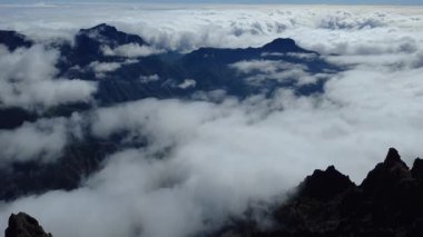 Bulutların üstündeki hava manzarası Caldera de Taburiente Ulusal Parkı 'nın çarpıcı volkanik kaya oluşumlarına bakıyor.