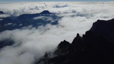 Bulutların üstündeki hava manzarası Caldera de Taburiente Ulusal Parkı 'nın çarpıcı volkanik kaya oluşumlarına bakıyor.