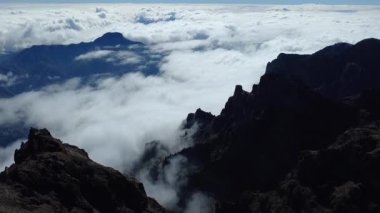Bulutların üstündeki hava manzarası Caldera de Taburiente Ulusal Parkı 'nın çarpıcı volkanik kaya oluşumlarına bakıyor.