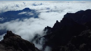 Bulutların üstündeki hava manzarası Caldera de Taburiente Ulusal Parkı 'nın çarpıcı volkanik kaya oluşumlarına bakıyor.