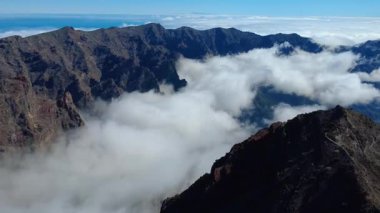 Bulutların üstündeki hava manzarası Caldera de Taburiente Ulusal Parkı 'nın çarpıcı volkanik kaya oluşumlarına bakıyor.