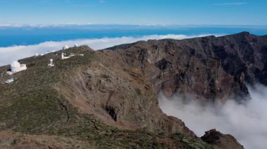 Bulutların üstündeki hava manzarası Caldera de Taburiente Ulusal Parkı 'nın çarpıcı volkanik kaya oluşumlarına bakıyor.