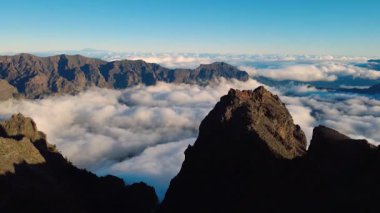 Bulutların üstündeki hava manzarası Caldera de Taburiente Ulusal Parkı 'nın çarpıcı volkanik kaya oluşumlarına bakıyor.