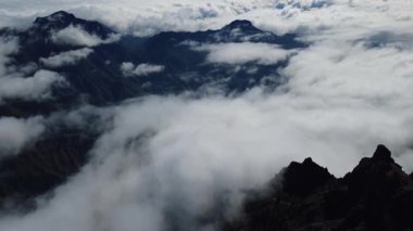 Bulutların üstündeki hava manzarası Caldera de Taburiente Ulusal Parkı 'nın çarpıcı volkanik kaya oluşumlarına bakıyor.