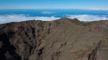 Bulutların üstündeki hava manzarası Caldera de Taburiente Ulusal Parkı 'nın çarpıcı volkanik kaya oluşumlarına bakıyor.