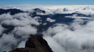 Bulutların üstündeki hava manzarası Caldera de Taburiente Ulusal Parkı 'nın çarpıcı volkanik kaya oluşumlarına bakıyor.