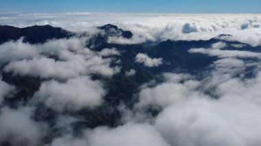 Bulutların üstündeki hava manzarası Caldera de Taburiente Ulusal Parkı 'nın çarpıcı volkanik kaya oluşumlarına bakıyor.