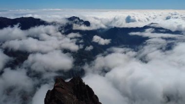 Bulutların üstündeki hava manzarası Caldera de Taburiente Ulusal Parkı 'nın çarpıcı volkanik kaya oluşumlarına bakıyor.