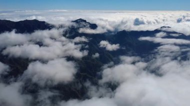 Bulutların üstündeki hava manzarası Caldera de Taburiente Ulusal Parkı 'nın çarpıcı volkanik kaya oluşumlarına bakıyor.
