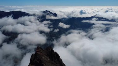 Bulutların üstündeki hava manzarası Caldera de Taburiente Ulusal Parkı 'nın çarpıcı volkanik kaya oluşumlarına bakıyor.