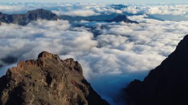 Bulutların üstündeki hava manzarası Caldera de Taburiente Ulusal Parkı 'nın çarpıcı volkanik kaya oluşumlarına bakıyor.