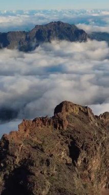 Bulutların üstündeki hava manzarası Caldera de Taburiente Ulusal Parkı 'nın çarpıcı volkanik kaya oluşumlarına bakıyor.