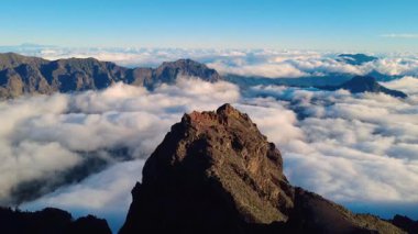 Bulutların üstündeki hava manzarası Caldera de Taburiente Ulusal Parkı 'nın çarpıcı volkanik kaya oluşumlarına bakıyor.