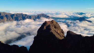 Bulutların üstündeki hava manzarası Caldera de Taburiente Ulusal Parkı 'nın çarpıcı volkanik kaya oluşumlarına bakıyor.