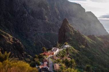 Tenerife 'deki Masca Vadisi' nin manzarası, Kanarya Adası, İspanya. Tenerife 'de palmiye ağaçları ve tropikal bitki örtüsü olan manzaralı bir dağ manzarası. Masca köyünde ünlü volkanik kaya oluşumu
