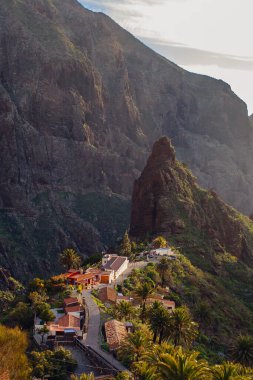 Tenerife 'deki Masca Vadisi' nin manzarası, Kanarya Adası, İspanya. Tenerife 'de palmiye ağaçları ve tropikal bitki örtüsü olan manzaralı bir dağ manzarası. Masca köyünde ünlü volkanik kaya oluşumu