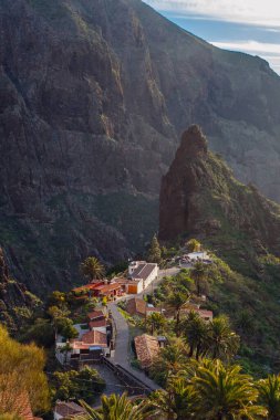 Tenerife 'deki Masca Vadisi' nin manzarası, Kanarya Adası, İspanya. Tenerife 'de palmiye ağaçları ve tropikal bitki örtüsü olan manzaralı bir dağ manzarası. Masca köyünde ünlü volkanik kaya oluşumu