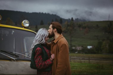 Kerpe Dağları'nda sarı araba yakınındaki aşık Çift