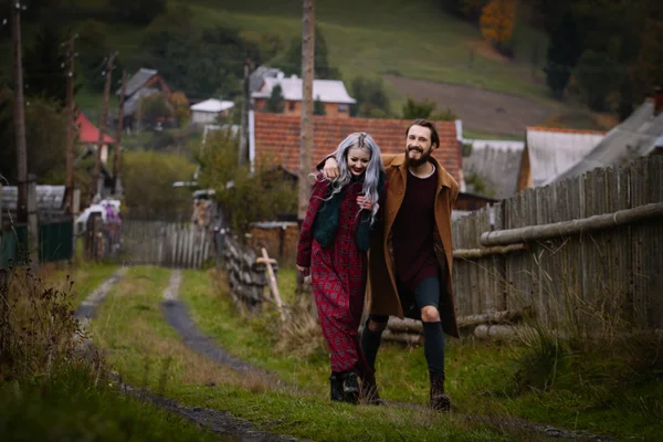 Young happy romantic couple on wooden fence — Stock Photo, Image