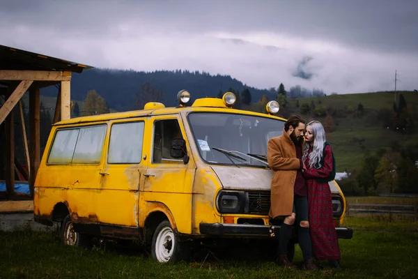 Para zakochanych w pobliżu żółty samochód w góry na wyspie Karpathos — Zdjęcie stockowe