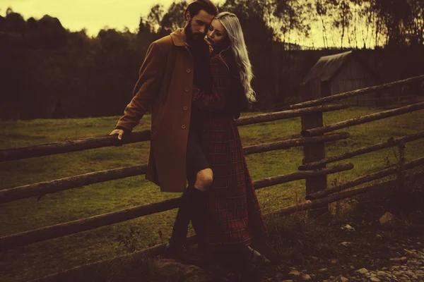 Молодая счастливая романтическая пара на деревянном заборе — стоковое фото