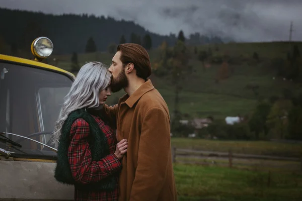 In de buurt van gele auto in Karpathian bergen verliefde paar — Stockfoto