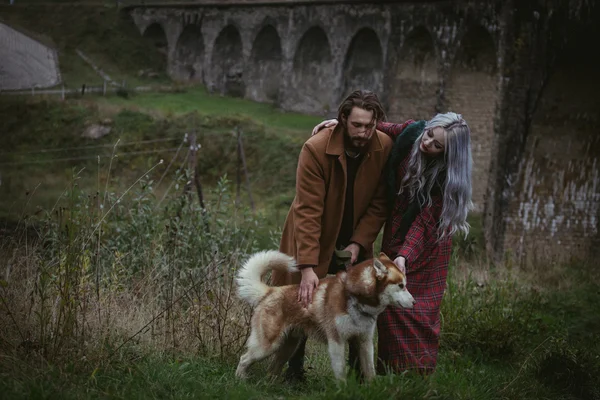 Влюбленная пара с собакой возле моста — стоковое фото