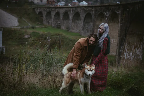 Par i kärlek med hund nära bridge — Stockfoto