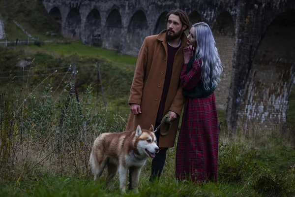 Couple in love with dog near bridge — Stock Photo, Image