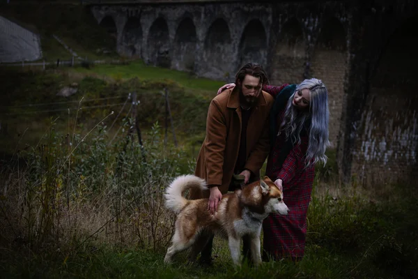 Casal apaixonado por cão perto da ponte — Fotografia de Stock