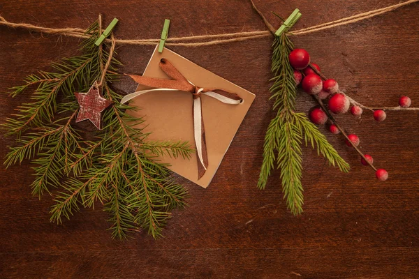 Ramas de pino con bayas navideñas y postal — Foto de Stock