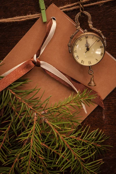 Ramos de pinheiro, relógio retrô e cartão postal — Fotografia de Stock