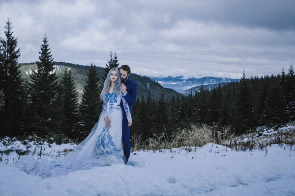 Piękne panny młodej i pana młodego w śniegu na górze — Zdjęcie stockowe