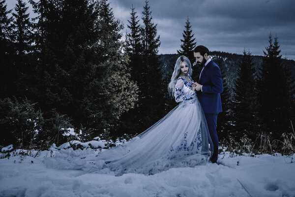 Bride and groom in winter snow on mountain