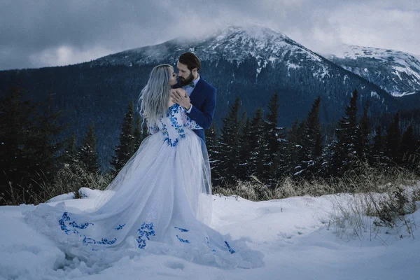 Krásná nevěsta a ženich v zimě sníh na horských — Stock fotografie