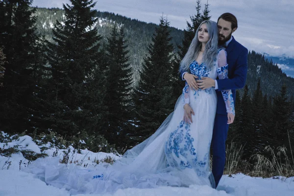 Mooie bruid en bruidegom in wintersneeuw op de berg — Stockfoto