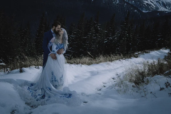 Lovely bride and groom in winter snow on mountain — Stock Photo, Image