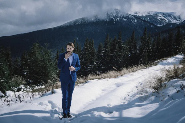 Noivo elegante em montanhas na neve — Fotografia de Stock