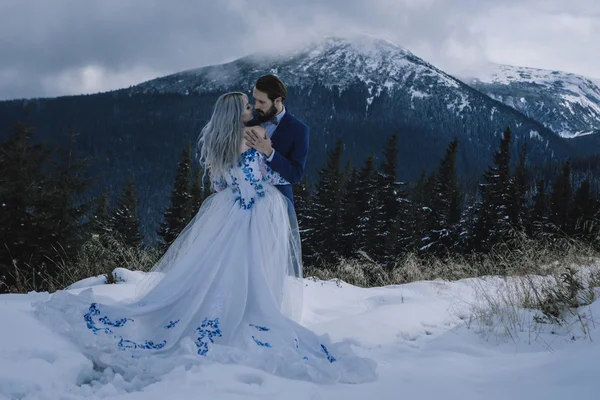 Belle mariée et marié dans la neige d'hiver sur la montagne — Photo