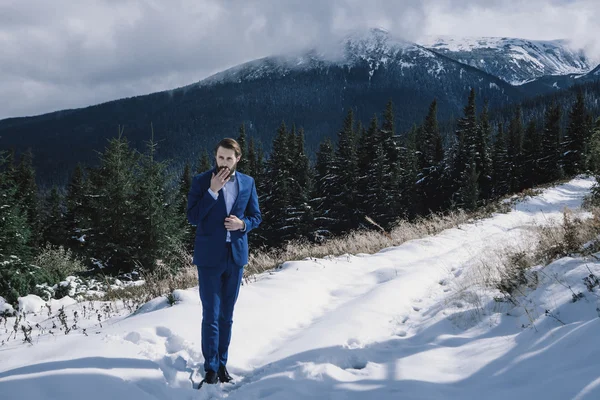 Noivo elegante em montanhas na neve — Fotografia de Stock