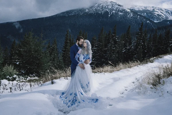 Krásná nevěsta a ženich v zimě sníh na horských — Stock fotografie