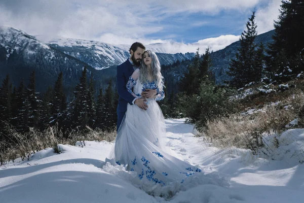 Krásná nevěsta a ženich v zimě sníh na horských — Stock fotografie