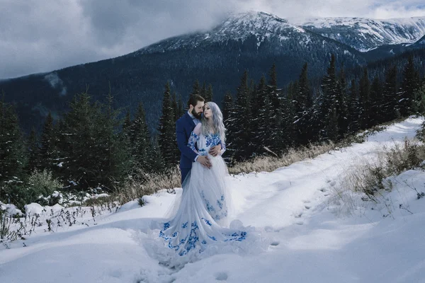 Όμορφη νύφη και το γαμπρό στο χειμώνα χιόνι στο βουνό — Φωτογραφία Αρχείου